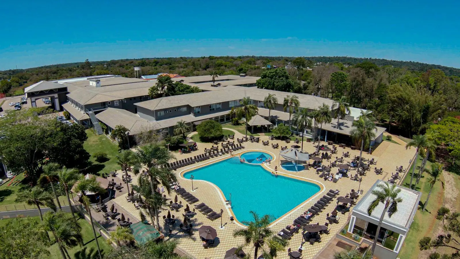 Vista aérea do Grand Carimã Resort, em Foz do Iguaçu, destaca a piscina externa e as áreas de lazer do empreendimento. Crédito: Divulgação