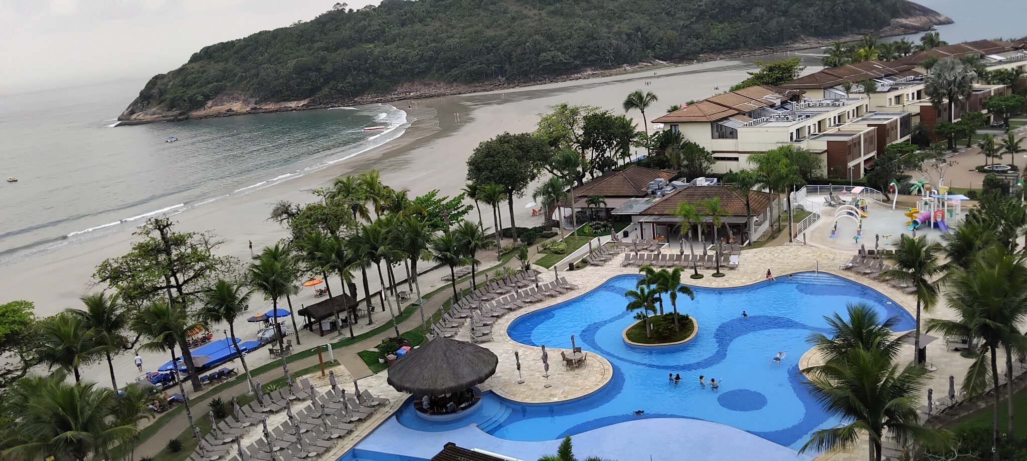 Complexo de piscinas do Jequitimar tem como cenário a Praia de Pernambuco, reforçando a característica pé na areia do resort — Foto: Denis Rugeri