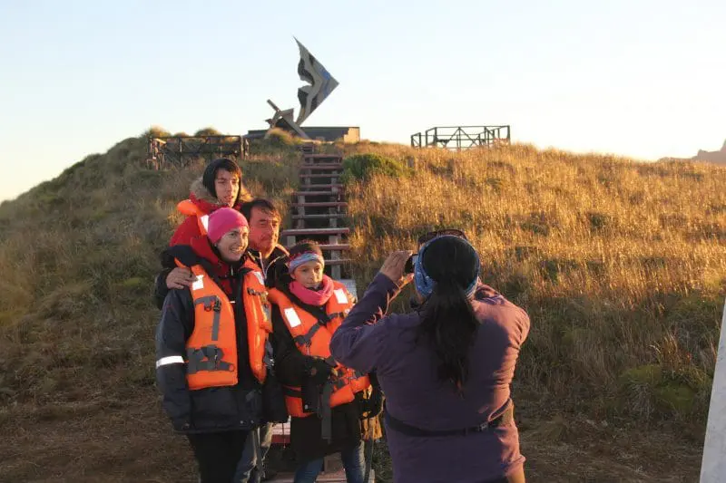 Turistas posam para a fotografia, diante do monumento