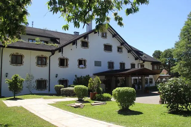 Cheguei um pouco antes, andei pelos jardins bem cuidados, fotografei a casa-hotel por fora e por uns instantes desembarquei em um país entre os Alpes