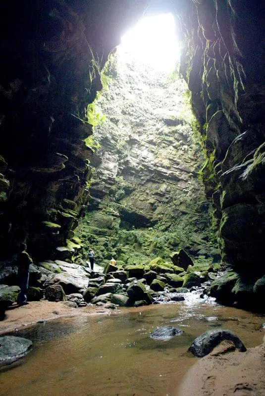 Buraco do Padre: O nome do local está ligado à história dos Padres Jesuítas que lá meditavam. O Buraco do Padre é uma furna que apresenta em seu interior uma imponente cascata de 30m, formada pelo Rio Quebra Perna. Trata-se de uma espécie de anfiteatro subterrâneo (Foto: Wanter Alves)