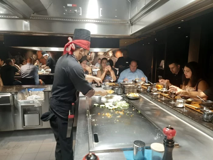 Chef prepara os pratos no Restaurante Kaito Teppanyaki com profissionalismo e diversão