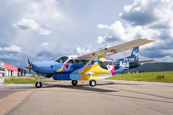 Lateral da aeronave “Rota das Emoções”, que possui tons de azul escuro, azul claro, amarelo e rosa. O avião é um que a Azul Conecta mostra ao público.