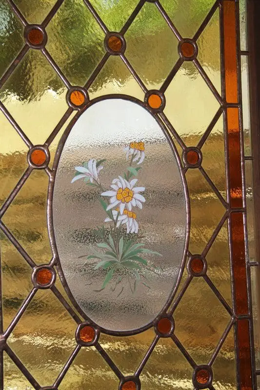 Jussara aponta para os vitrais que têm a flor Edelweiss em seu centro