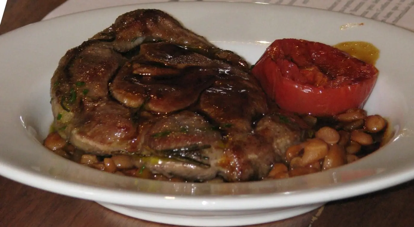Pernil de carneiro com feijão carioca temperado com bacon, cenoura e cebola, pesto de salsa e tomate confitado. (Foto: DT)