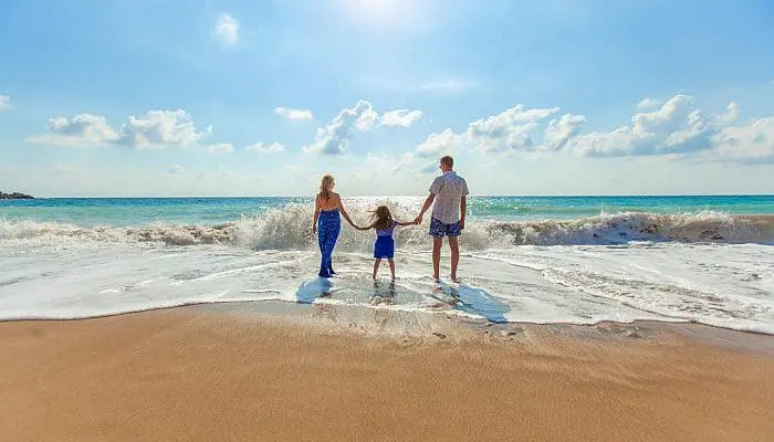 familia_em_freias_na_praia_unsplash Família de férias na beira da praia foto Natalya Zaritskaya - Unplash