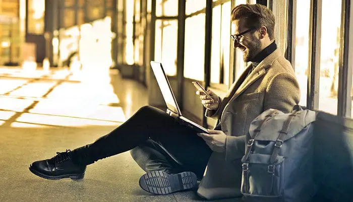 Passageiro usa notebook e smartphone em aeroporto