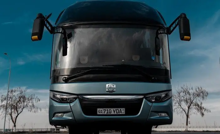 Visão frontal de um ônibus de fretamento para viagem estacionado.