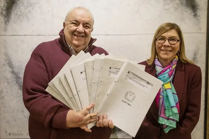 Prefeito de Curitiba, Rafael Greca, lança novos editais culturais no valor de R$ 3,1 milhões e mostra-os em foto. Ao lado de Rafael, está Ana Cristina de Castro, presidente da Fundação Cultural de Curitiba.