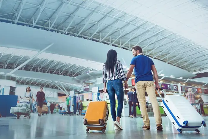 Mais passageiros utilizarão os aeroportos na alta temporada europeia: casal no aeroporto