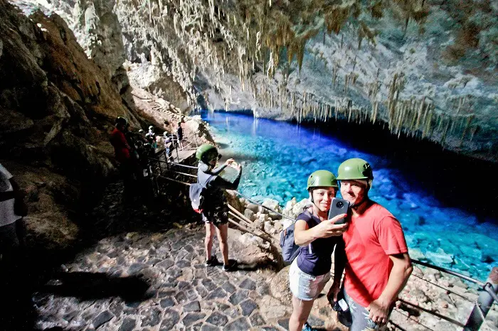 Pesquisa sobre ecoturismo brasileiro: imagem de pessoas tirando foto em uma caverna de Bonito (MS)