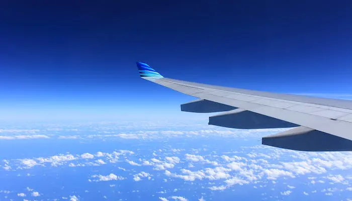 Aéreas brasileiras ficam longe das melhores do mundo em 2023, aponta AirHelp Score: foto da asa de um avião, que está sobrevoando algumas nuvens, e o céu está azul