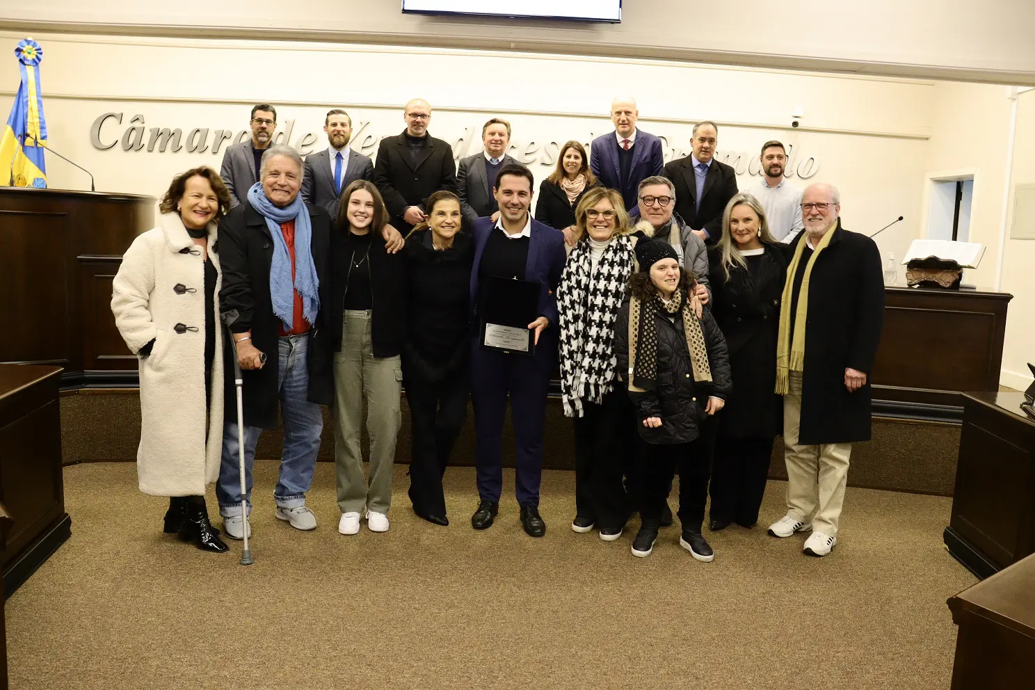 Nigia, Enoir (pai), Eduarda (filha), Marta Rossi, Eduardo, Mari, Caco, Helena, Juliana (esposa) e Prade. Ao fundo os vereadores Rodrigo Paim, Renan Sartori, Cìcero Altreiter, Celso Fioreze, Rosi Schmitt, Professor Daniel, Neri Nascimento e Ike Koetz (Foto: Paulo Vargas/Câmara de Vereadores de Gramado)