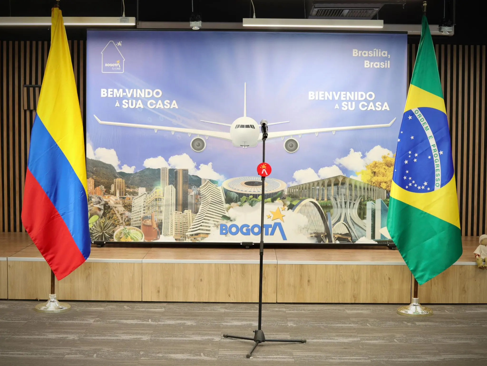 O palco do encontro que reuniu autoridades e executivos no aeroporto El Dorado, em Bogotá, no início da tarde da terça-feira (4), trouxe as bandeiras do Brasil e da Colômbia e fez menção à união das capitais de ambos os países, que a GOL passa a ligar com voos diretos a partir de hoje (Foto: Divulgação)