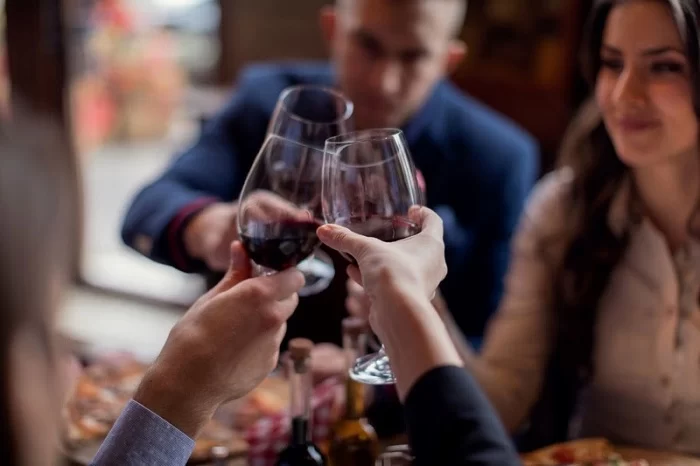 Pessoas com taças de vinho brindando. O Hyatt Wine Club oferece degustação de vinhos brasileiros em edição especial.