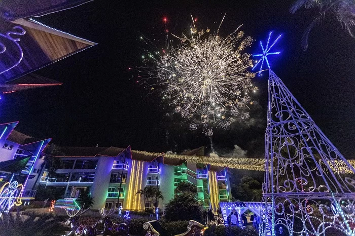 Entrada do Recanto Cataratas, com árvore de Natal iluminada à esquerda e show de fogos de artifício no céu, no Reveillón. Recanto Cataratas aumenta receita em 2022 e deseja novos mercados.