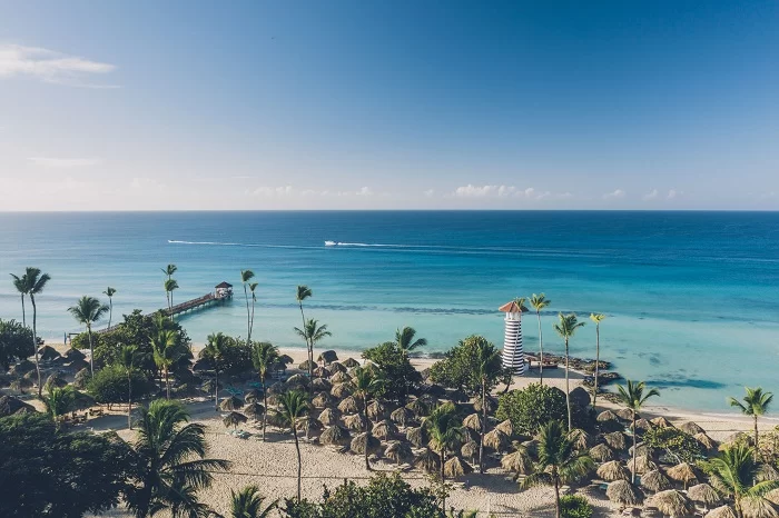 Visão da praia, com o farol à direita da foto, e do mar azul turquesa que beira o Iberostar Selection Hacienda Dominicus.