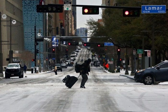 © Reuters. Pedestre caminha na rua durante passagem de frente fria por Dallas 01/02/2023. Por conta da tempestade, os voos foram cancelados.